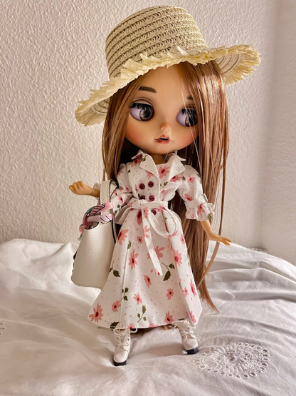 Neo Blythe doll wearing a floral dress and straw hat with a handbag, showcasing a stylish outfit.