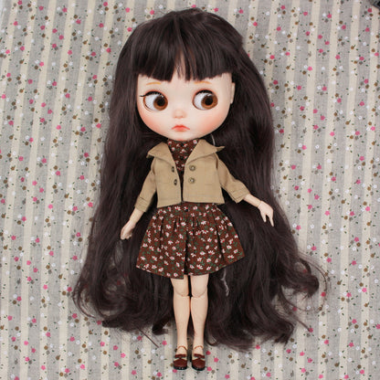 Neo Blythe doll wearing a brown jacket and floral dress on a patterned background. Perfect for BJD collectors.