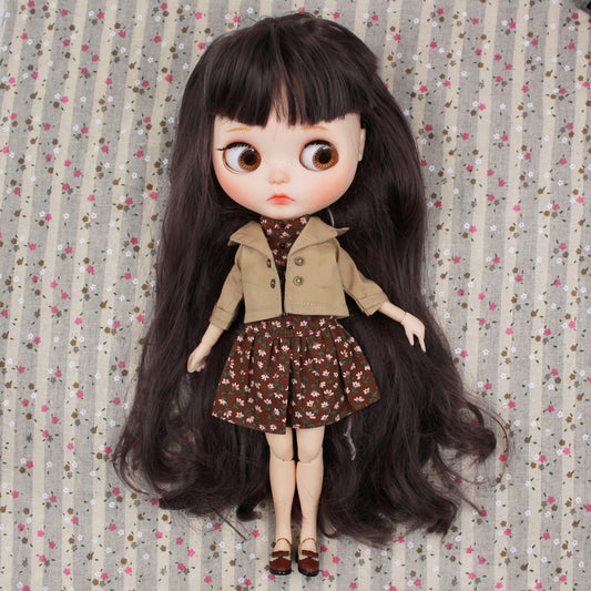 Neo Blythe doll wearing a brown jacket and floral dress on a patterned background. Perfect for BJD collectors.
