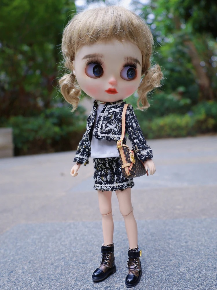 Neo Blythe doll in a tweed jacket set, showcasing a stylish outfit with a handbag, standing outdoors.