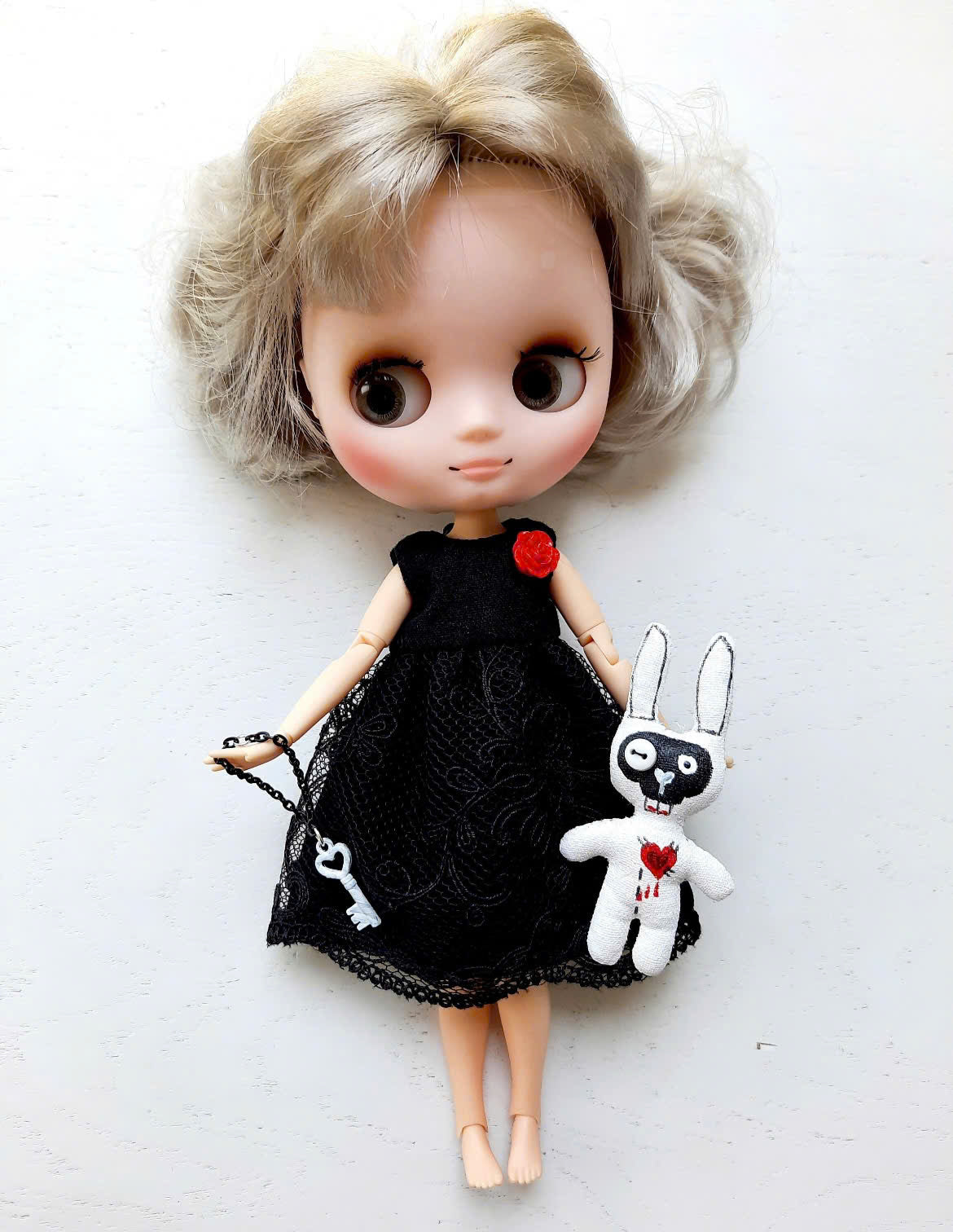 Middie Blythe Doll with blonde curly hair in a black dress, holding a bunny and key accessories.
