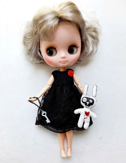 Middie Blythe Doll with blonde curly hair in a black dress, holding a bunny and key accessories.